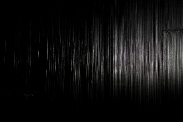 Black painting in raking light, vertical striations