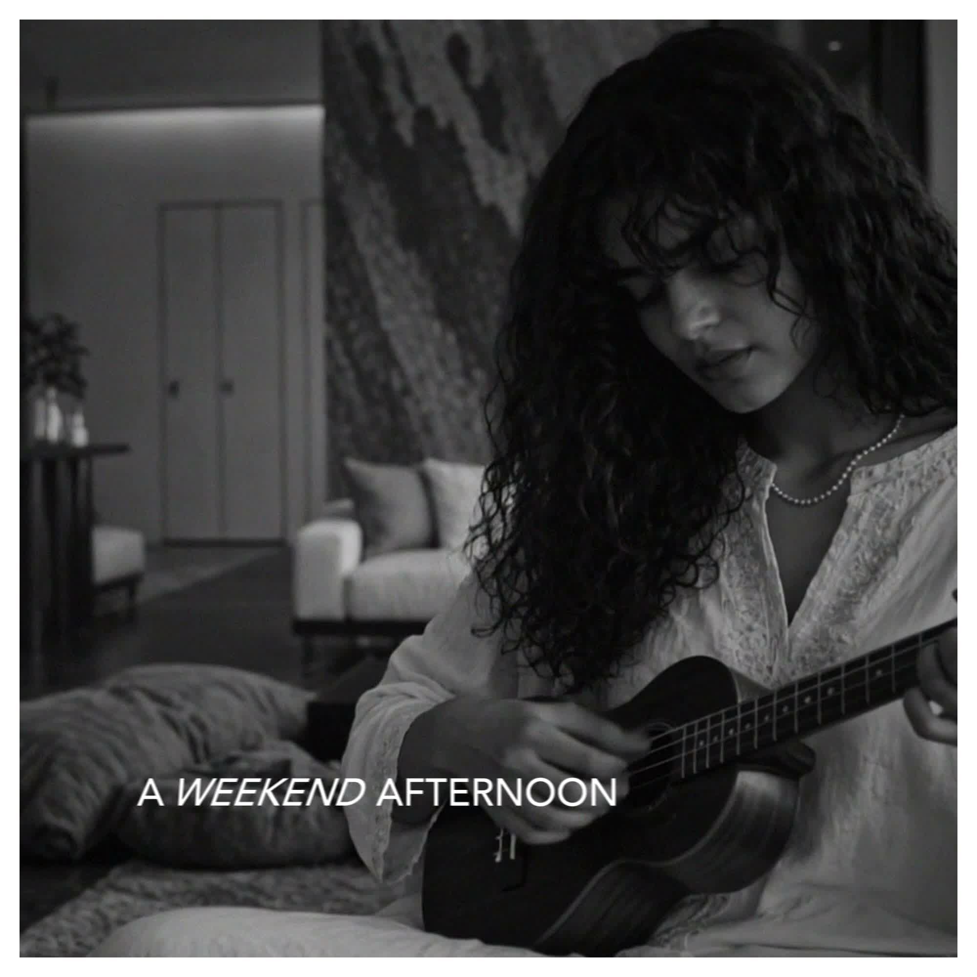 Still from A Weekend Afternoon: playing a ukulele on the sofa